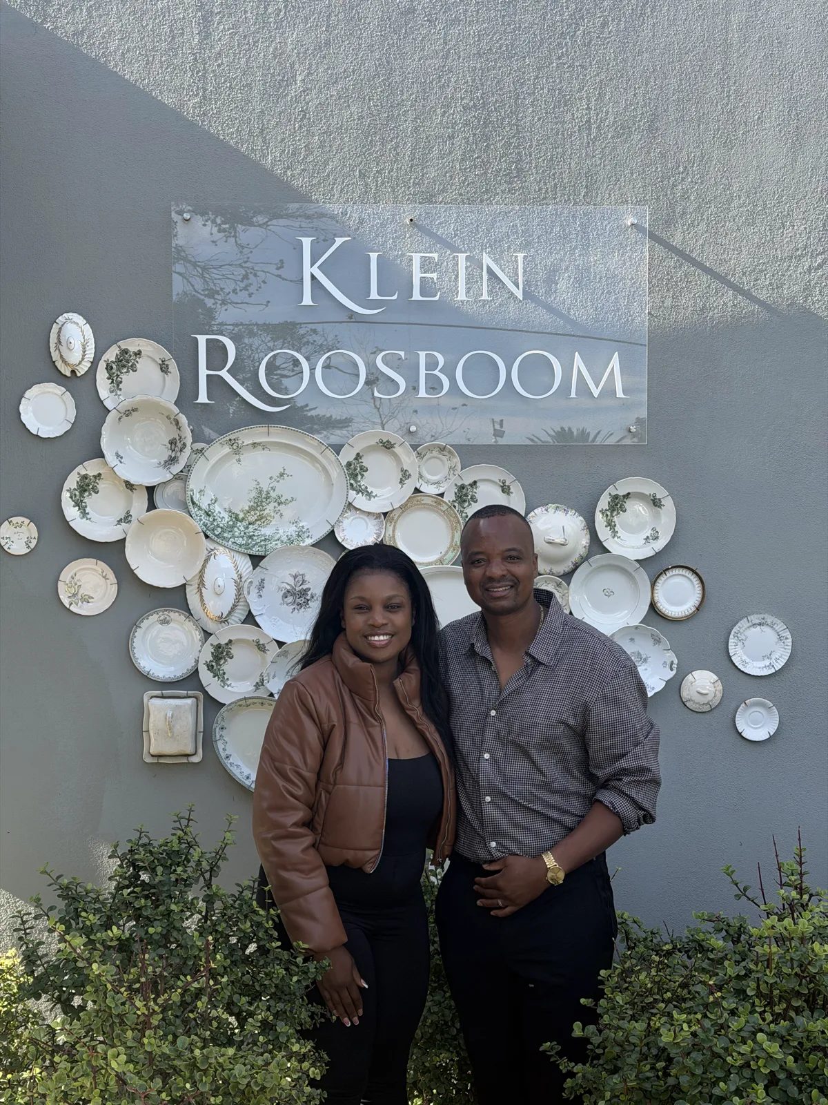 Two visitors outside the Klein Roosboom tasting room, in front of its wall of vintage plates