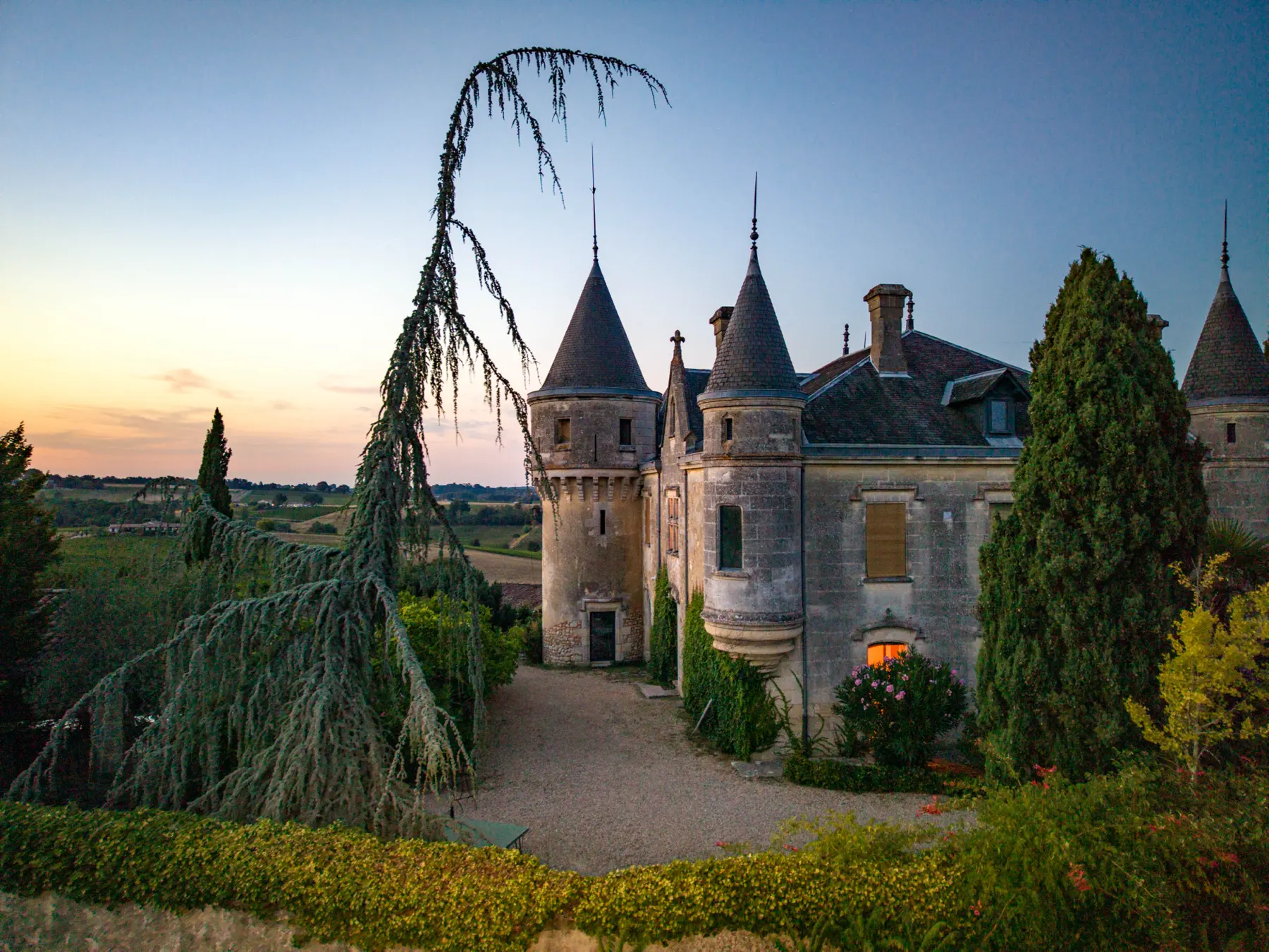 Château de la Grave framed by trees on its drive