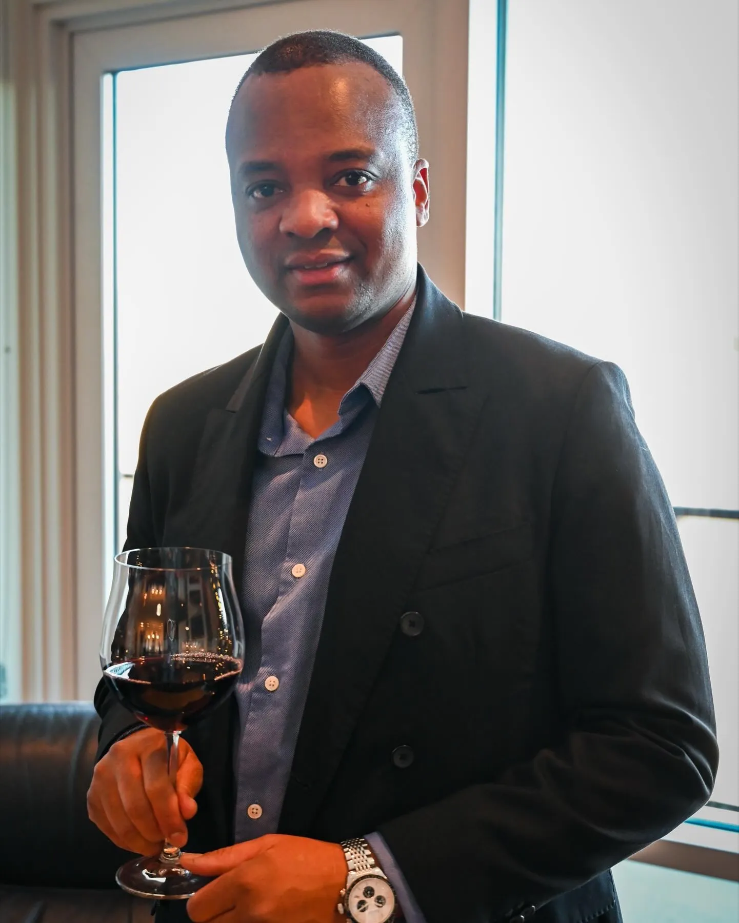 Rawlings Munemo, founder of Enotri Wine Imports, holding a glass of red wine